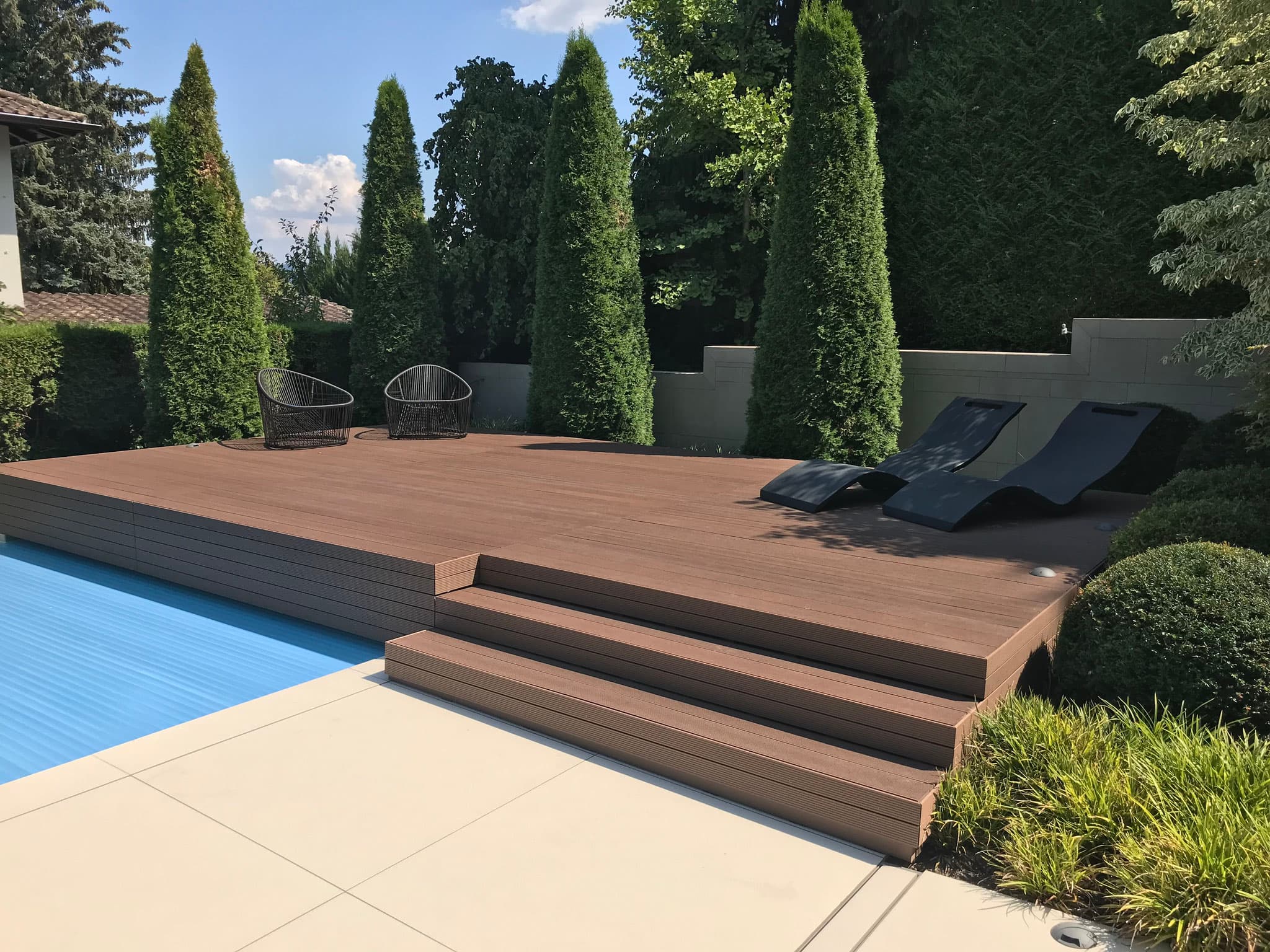 Moderne WPC Terrasse mit Liegen am Pool